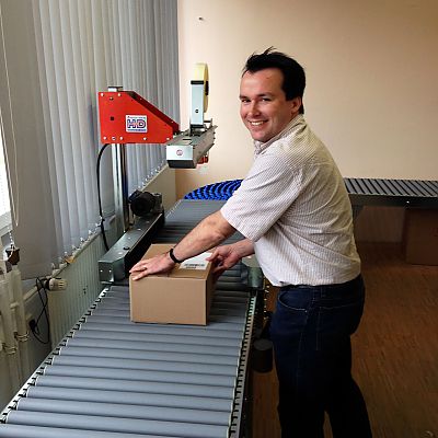 Oktober 2013: Zu Besuch bei unserem Kunden Bettwaren-Shop auf der Schwäbischen Alb. Auf dem Bild "begleitet" Thomas ein Paket auf dem Weg durch die funkelnagelneue automatische Kartonverschließmaschine.